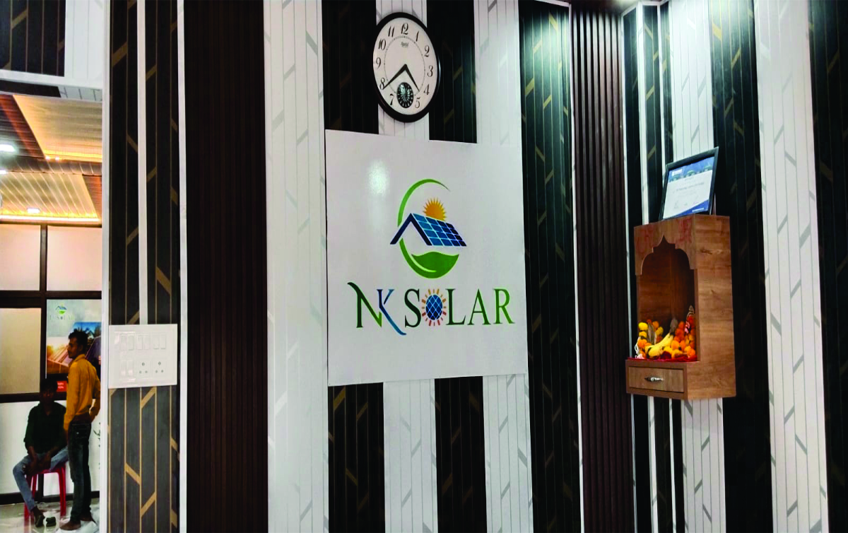 White color vinyl with name NK Solar pasted on black and white color lining wall in Lucknow